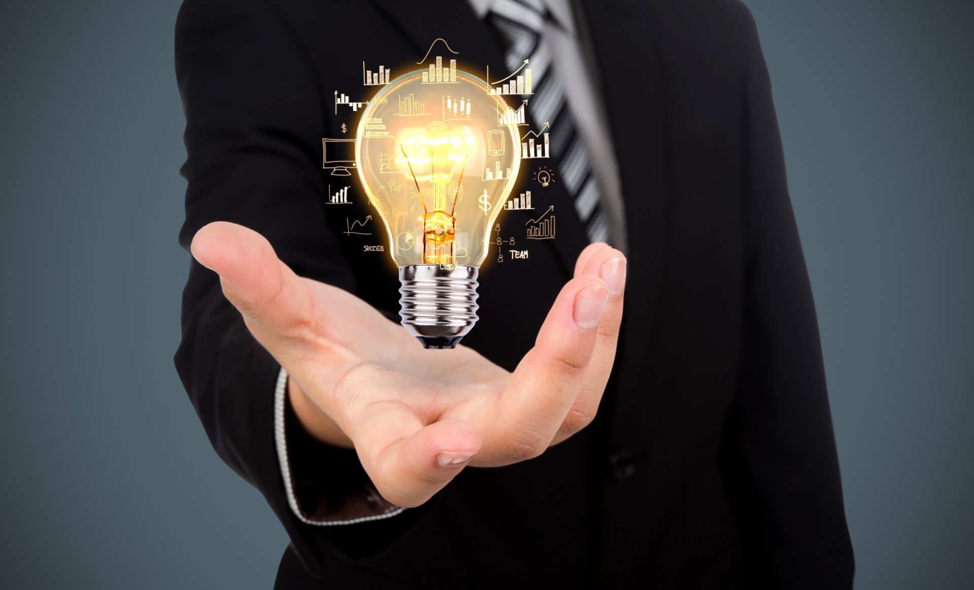A person in a suit holds out their hand with a glowing lightbulb above it, surrounded by business and technology icons.